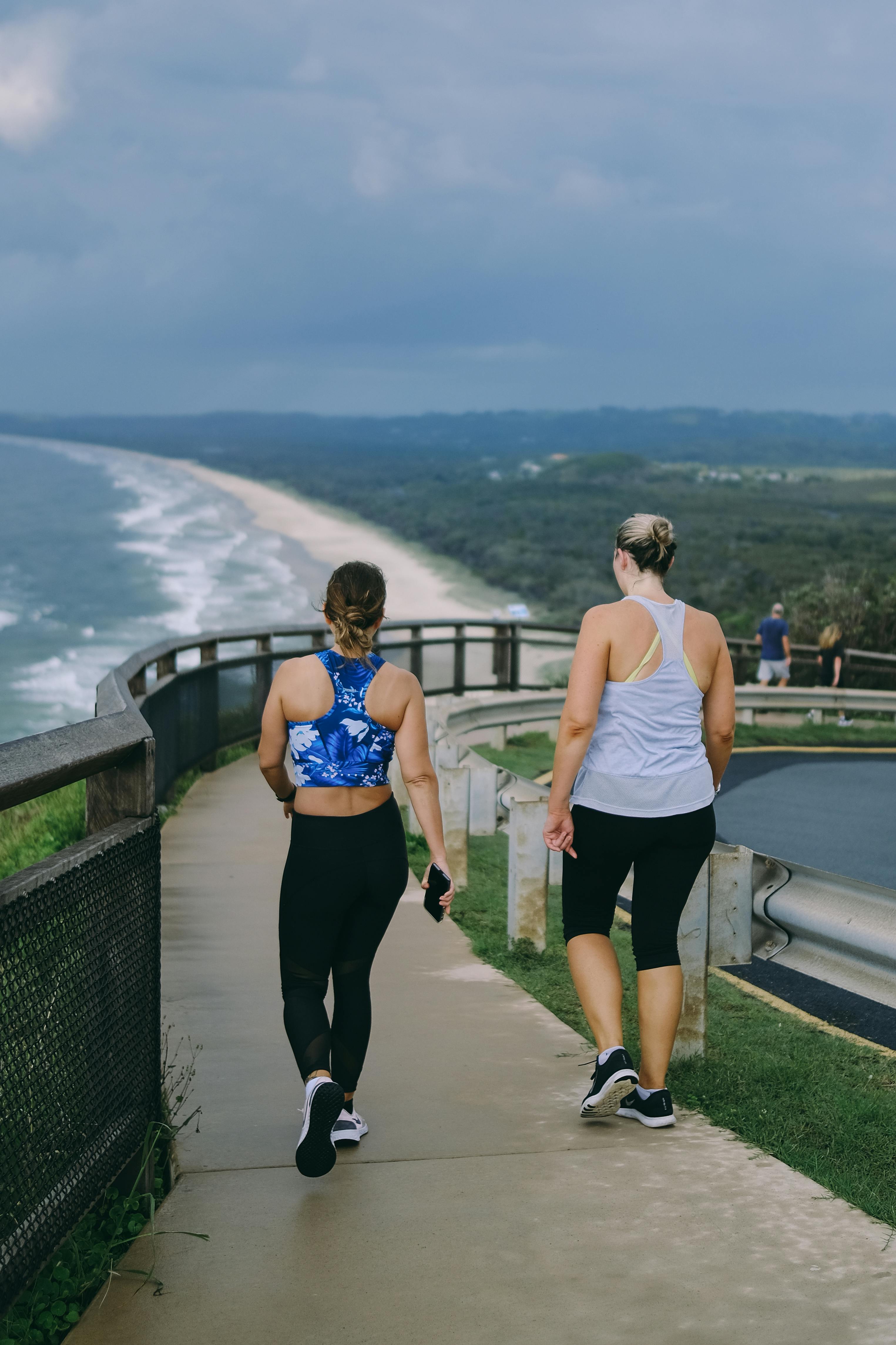 Two women walking a coastal boardwalk on a moody overcast morning.
